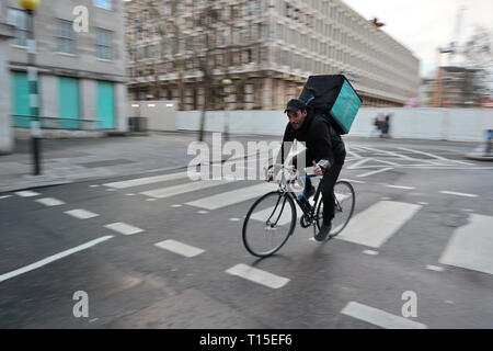 Deliveroo cycle rider Daumen hoch, als er warme Speisen an Kunden in Mayfair, London, England, UK liefert Stockfoto