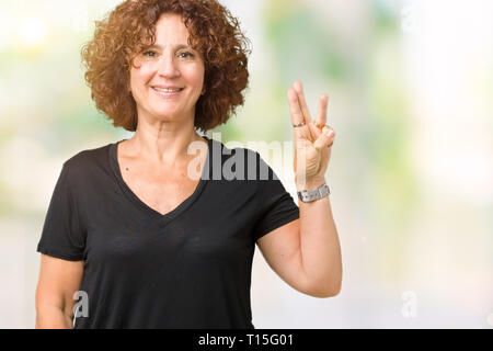 Schöne Mitte ager Senior Frau über isolierte Hintergrund angezeigt und zeigen mit den Fingern Nummer drei, während lächelte zuversichtlich und fröhlich. Stockfoto