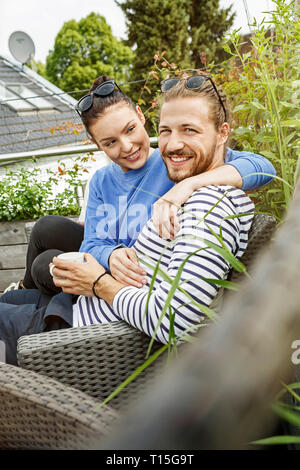 Junges Paar entspannen Sie auf Ihrem Balkon sitzen auf der Couch Stockfoto