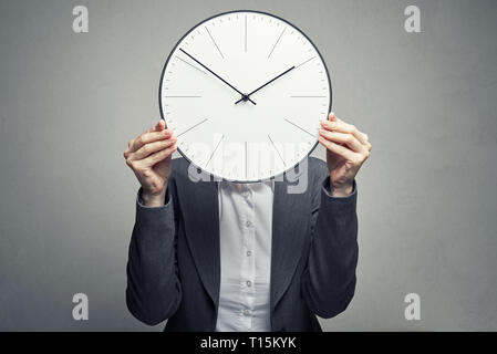 Business Frau in weißer Bluse und Klage über ihr Gesicht mit Uhr Stockfoto