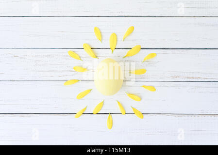 Kreatives Konzept aus Hühnerei und Blüten wie eine Sonne auf weißem Hintergrund Stockfoto
