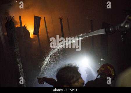 Dhaka, Bangladesch. 23 Mär, 2019. In der Finsternis Feuerwehrleute versuchen, ein Feuer, das an einem Papier Lager bei Lalbagh im Old Dhaka, Bangladesch brach zu steuern. Vor kurzem am 20. Februar 2019 mehr als 70 Menschen wurden getötet, als eine massive Ausbreitung des Feuers durch mehrere Wohnhäuser in der Hauptstadt von Bangladesch. Credit: Zakir Hossain Chowdhury/ZUMA Draht/Alamy leben Nachrichten Stockfoto