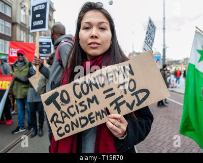 Amsterdam, Nordholland, Niederlande. 23 Mär, 2019. Eine Frau gesehen, die ein Plakat gegen die rechtsextremen politischen Partei FvD während der Demonstration. Tausende von Menschen an den Dam Platz im Zentrum von Amsterdam versammelt, um gegen Rassismus und Diskriminierung zu demonstrieren. Sie bitten um Vielfalt und Solidarität, gegen alle Formen von Rassismus und Diskriminierung. Auch gegen die beiden politischen Parteien der extremen Rechten in den Niederlanden, die Pvv und der FvD, die ihre Macht während der letzten Wahlen im Land zugenommen haben. Eine kleine rechtsextreme Gruppe zeigte sich während der Wanderung, die zwei großen Stockfoto