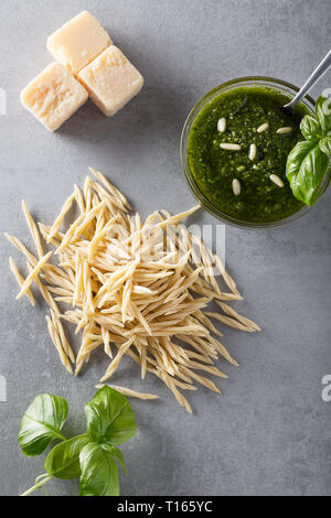 Hausgemachte grüne Basilikum Pesto und frischen Zutaten. Italienische Küche. Ansicht von oben mit der selektiven weichzeichner. Gesunde Lebensmittel, Ernährung und Kochen. Stockfoto