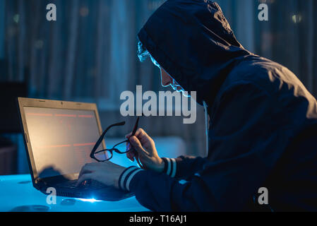 Eine männliche Hacker in Gläsern Nachdenken über das Problem der Hacking und Diebstahl von Access Datenbanken mit Passwörtern. Das Konzept der Cybersicherheit Stockfoto