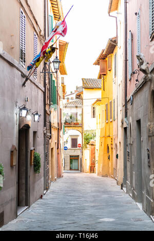 Chiusi, Italien leere Straße in kleinen Stadt Dorf in Umbrien Toskana schmalen vertikalen Ansicht bei Tag mit orange rosa gelb hell leuchtende, brillante Farben Stockfoto