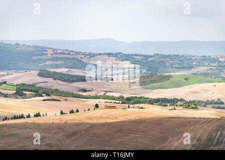 Landschaft im Val D'Orcia Toskana, Italien mit Antenne Ballen rolling gepflügt braune Hügel und Villen mit Bauernhof Landschaft wiese Felder hohen Winkel Stockfoto