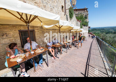 San Gimignano, Italien - 27 August, 2018: die Menschen sitzen, Wein trinken und im Cafe Restaurant im historischen Dorf in der Toskana essen während der sonnigen Sommer Stockfoto