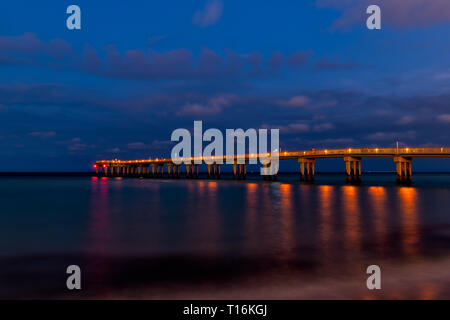 Sunny Isles Beach, USA Nacht abend in Miami, Florida mit Pier beleuchtete Reflexion mit langen Belichtungszeiten von ruhigem Meer Küste Stockfoto