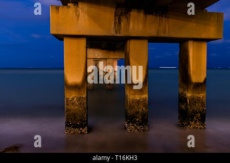 Sunny Isles Beach, USA Nacht abend in Miami, Florida mit Pier Struktur und lange Belichtung der Ruhe Ocean Shore Stockfoto