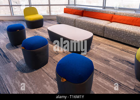Neue moderne Büro Zimmer oder an der Universität Halle in Gebäude mit leuchtenden Blau Gelb Rot Orange Stuhl Sofa und einem kleinen Tisch, Wand Fenster aus Glas, und niemand Stockfoto