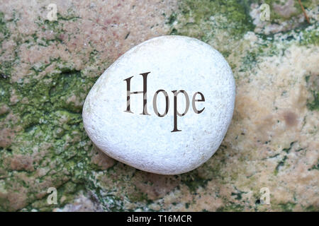 Hoffe, Worte auf weißem Stein oder Kies mit abstrakten Stein Hintergrund Stockfoto