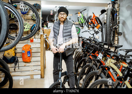 Porträt einer stilvollen Mann mit klapprad am Fahrrad Shop Stockfoto