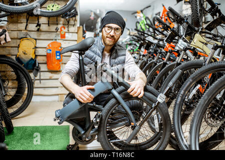 Porträt einer stilvollen Mann mit klapprad am Fahrrad Shop Stockfoto