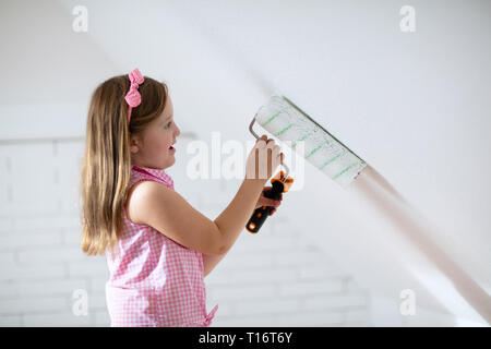 Kinder malen Dachgeschoss Wand. Home Verbesserung und Renovierung. Kind mit weißer Farbe auf Mauern im Schlafzimmer. Renovierung sky Salon mit Schrägen wa Stockfoto