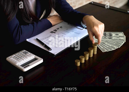 Geschäftsfrau picks Münzen auf den Tisch und zählt Geld. Geschäftskonzept. Stockfoto