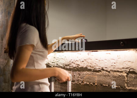 Close up Frauen rufen Sie das Hotel an der Rezeption auf dem Schreibtisch mit dem Finger drücken Sie eine Glocke in der Lobby Hotel. hotel Konzept. Stockfoto