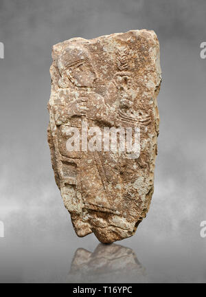 Hethiter monumentale Relief Skulptur eines sitzende Holding eine Weintraube. Archäologisches Museum Adana, Türkei. Vor grauem Hintergrund Kunst Stockfoto