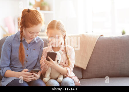 Kinder mit Smartphones zu Hause Stockfoto