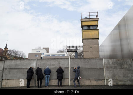 Menschen an der Gedenkstätte Berliner Mauer (Berliner Mauer) in Berlin, Deutschland. Der wachtturm ist hinter der Berliner Mauer. Die Dokumentation befindet sich in der backgroun Stockfoto