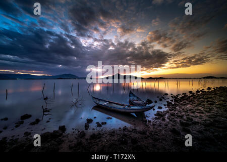 Schönen Sonnenaufgang an der Lagune mit dem Boot im Vordergrund. Das Konzept der einsame Gefühl Stockfoto