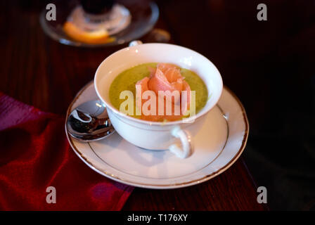 Cremesuppe mit Brokkoli und Lachs auf hölzernen Tisch Stockfoto