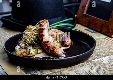 Traditionelle deutsche Würstchen mit Kartoffel serviert in der Wanne. Restaurant Dish. Seitenansicht Stockfoto