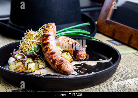 Traditionelle deutsche Würstchen mit Kartoffel serviert in der Wanne. Restaurant Dish. Seitenansicht Stockfoto