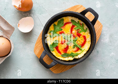 Omelette mit frischen Pfeffer und Rucola. Frittata in der Pfanne. Stockfoto