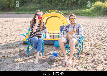 Leute, Sommer Tourismus und Natur Konzept - Junges Paar Tee trinken, in der Nähe von Zelt Stockfoto