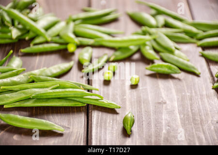 Viele ganz junge grüne Zucker snap Erbse auf braunem Holz Stockfoto