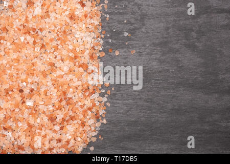 Viele Stücke von pink Himalaya Salzkristalle copyspace flatlay am grauen Stein Stockfoto