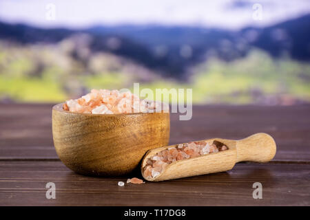 Viele Stücke von pink Himalaya-salz Kristalle in eine hölzerne Schüssel in die Berge Stockfoto