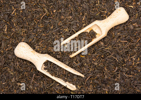 Viele Stücke von trockenen schwarzer Tee Earl Grey mit Holz- schaufel flatlay Stockfoto