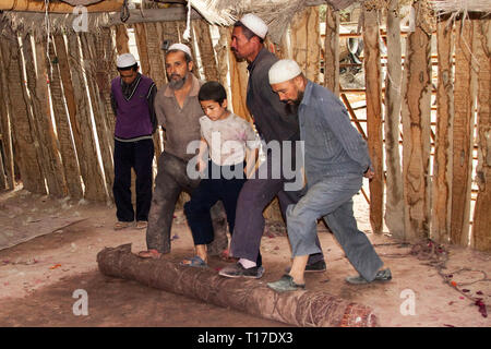 Filzherstellung, Walzen und Pressen von Wolle, ein kulturelles und traditionelles Handwerk in der Autonomen Region Xinjiang, China. Stockfoto