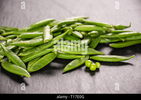 Viele ganz junge grüne Zucker snap Erbse am grauen Stein Stockfoto