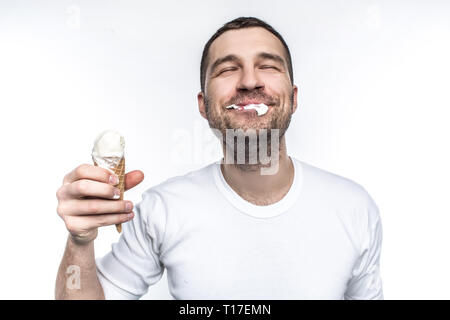 Fröhlich und freudig Mann ist Essen ein Eis nicht sehr genau, aber mit großer Freude. Auf weissem Hintergrund. Stockfoto