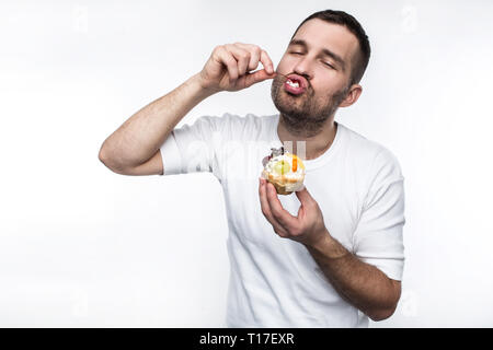 Erwachsene divouring süßen cremigen Nachspeise. Er genießt den Prozess der es Essen. Auf weissem Hintergrund. Stockfoto