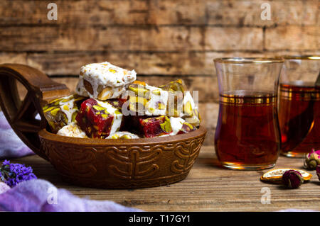 Türkische Köstlichkeiten mit Pistazien und Rose Blume in eine Schüssel geben. Stockfoto