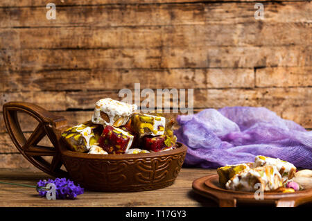 Türkische Köstlichkeiten mit Pistazien und Rose Blume in eine Schüssel geben. Stockfoto