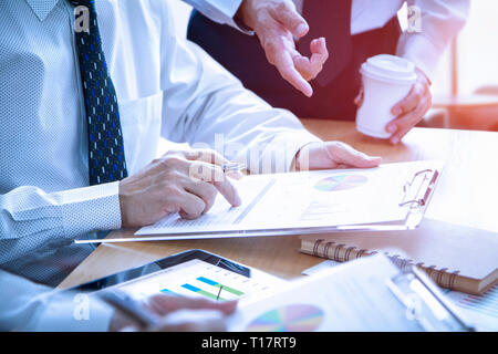 Geschäftsleute in einem Meeting sind zutiefst Überprüfung eine finanzielle Berichte für einen Return on Investment oder Investitionen Risikoanalyse. Stockfoto