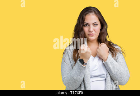 Schöne Übergrößen junge Frau tragen Winter Jacke über isolierte Hintergrund bereit mit Faust Verteidigung Geste zu kämpfen, wütend und verärgert Gesicht, Angst Stockfoto