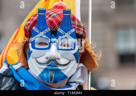 Glasgow, Schottland, Großbritannien. 24. März, 2019. Ein Mann mit einer Maske und einem Sehen Sie Jimmy hat verbindet Mitkämpfer für die schottische Unabhängigkeit, wie sie für eine Kundgebung auf dem George Square sammeln. Die Kundgebung der Gruppe Hoffnung über Furcht organisiert wurde. Credit: Skully/Alamy leben Nachrichten Stockfoto