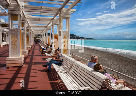 Stadt Nizza in Frankreich, Menschen auf Bänken in der Pergola an der Promenade des Anglais am Mittelmeer auf Französische Riviera Stockfoto