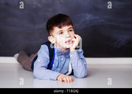 Süße kleine Junge im blauen Hemd Träumen zu Hause Stockfoto