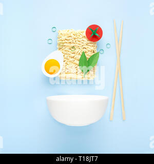 Kreative Ernährung Gesunde Ernährung Konzept Foto von lecker Ramen Nudeln Nudeln mit Gemüse Tomate ei grünen Stäbchen und Schüssel auf blauem Hintergrund. Stockfoto