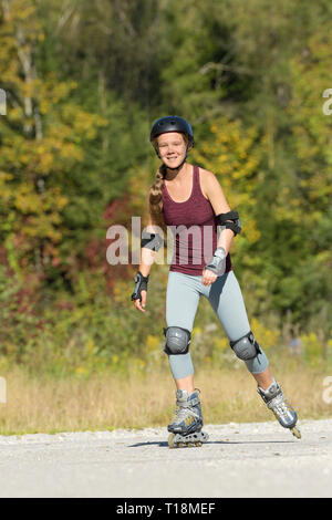 Junge Frau rollerblading im Spätsommer Stockfoto