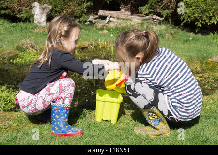 Zwei junge Mädchen Teich Eintauchen in Garten Tiere Teich Kaulquappen