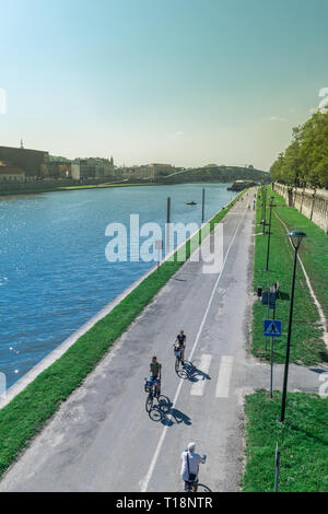 Krakau, Polen - 21. September 2019: Volk ist Wandern und Radfahren auf dem Radweg am Ufer der Weichsel, mit Kotlarski Brücke auf der Stockfoto