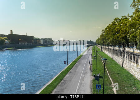 Krakau, Polen - 21. September 2019: Volk ist Wandern und Radfahren auf dem Radweg am Ufer der Weichsel, mit Kotlarski Brücke auf der Stockfoto